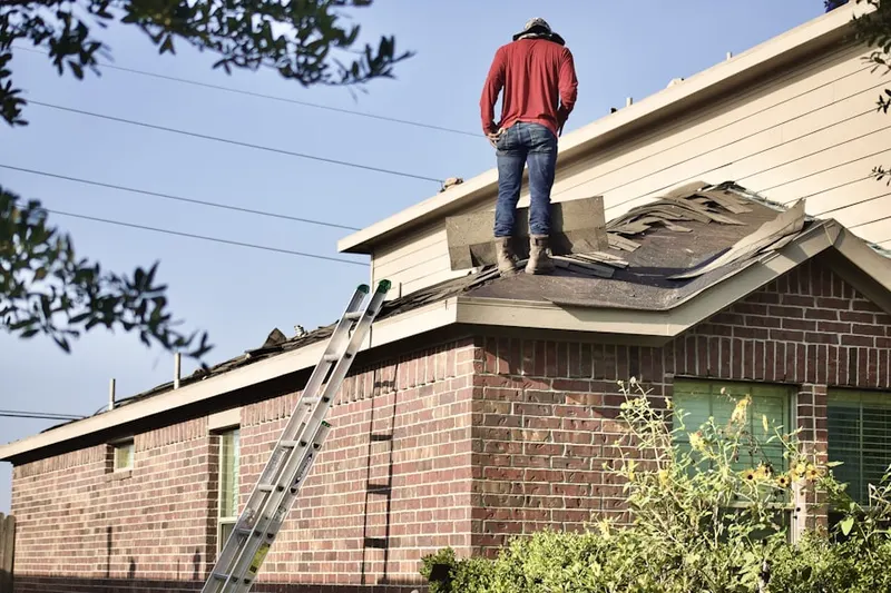 Professional roofer working on a residential roof in Highland